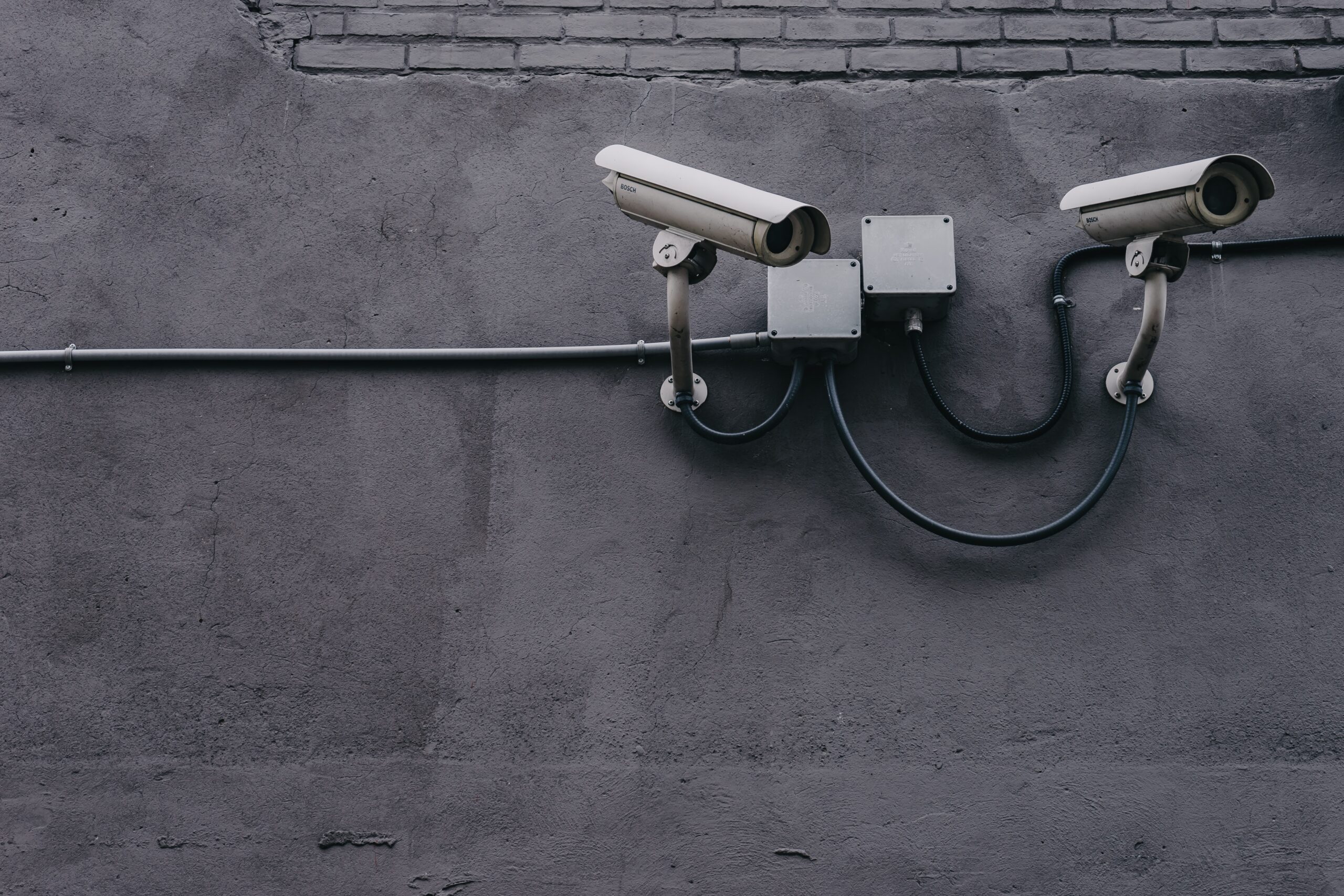 Two video cameras attached to a wall.