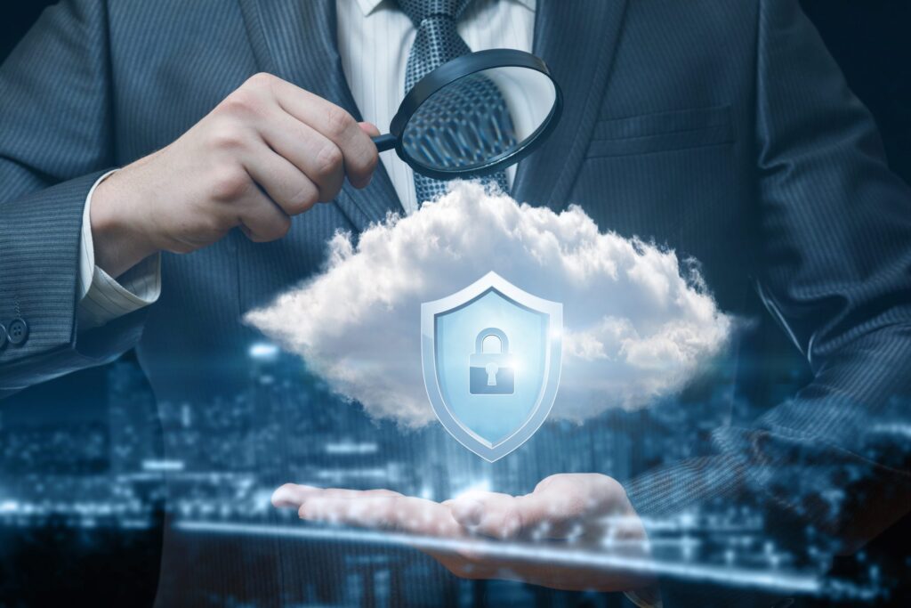 Businessman with a magnifying glass inspecting cloud security.